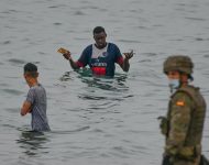 Španielsky vojak stojí na stráži, keď sa migranti dostávajú do španielskej exklávy Ceuta