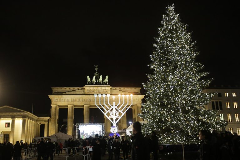 Izraelčan Or Elyakim zapálená štvrtá sviečka chanukový svietnik Pariser Platz Brandenburská brána v Berlíne